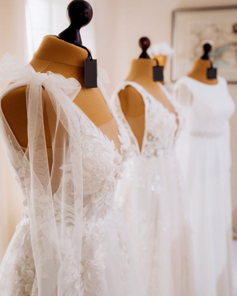 beautiful white wedding dresses hang on mannequins